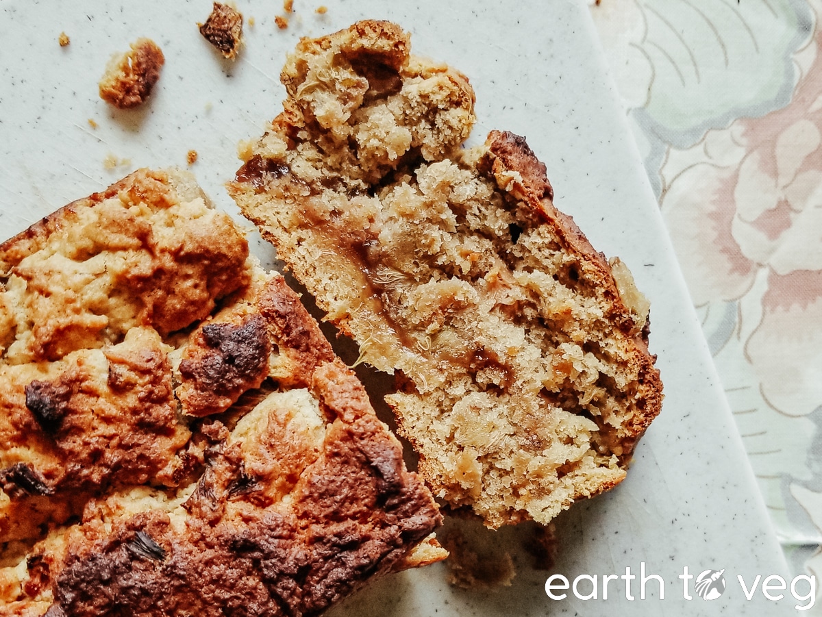 a slice of double rhubarb loaf rests on a white cutting board.