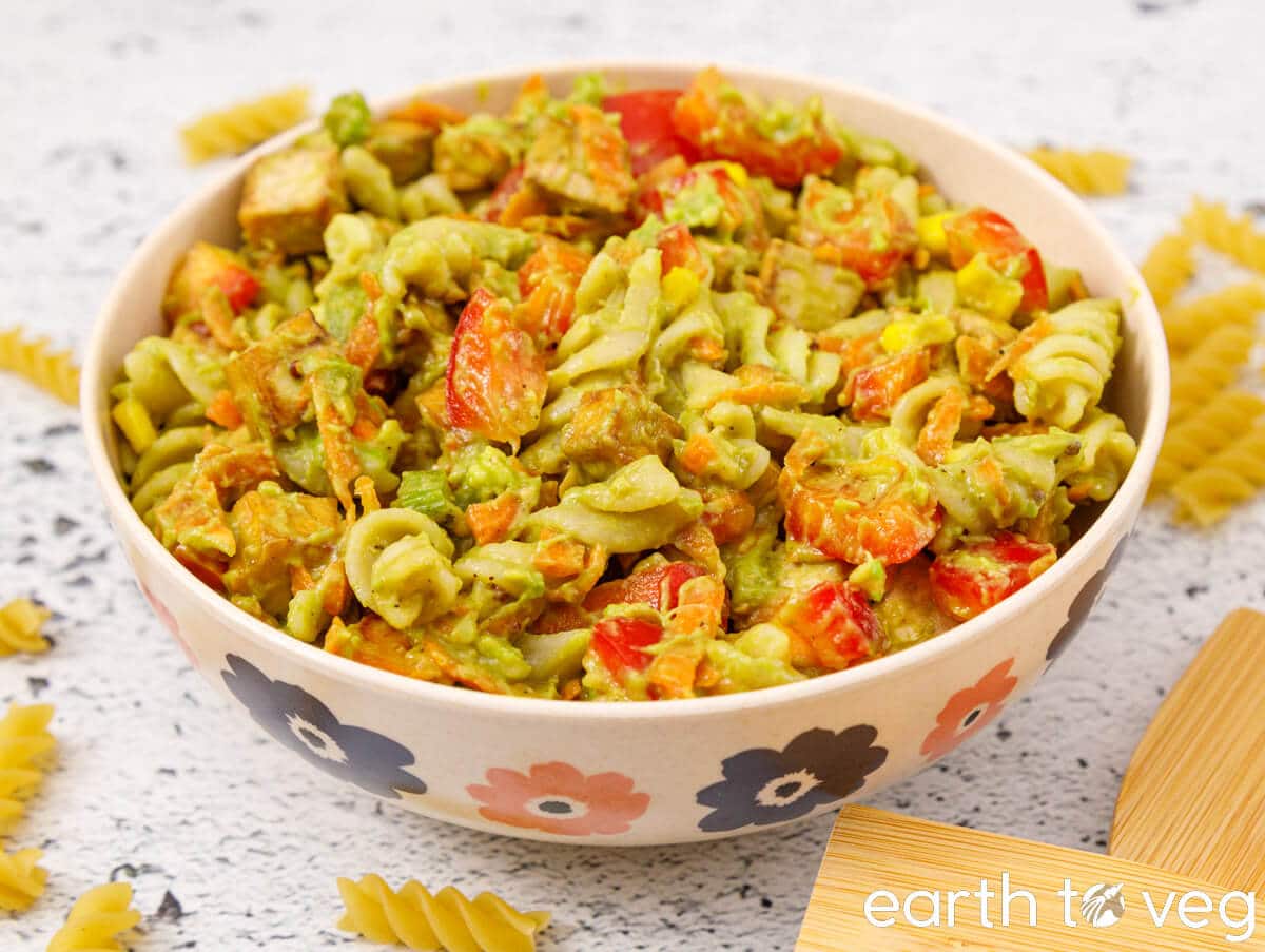A bowl of avocado tofu pasta salad on the countertop.