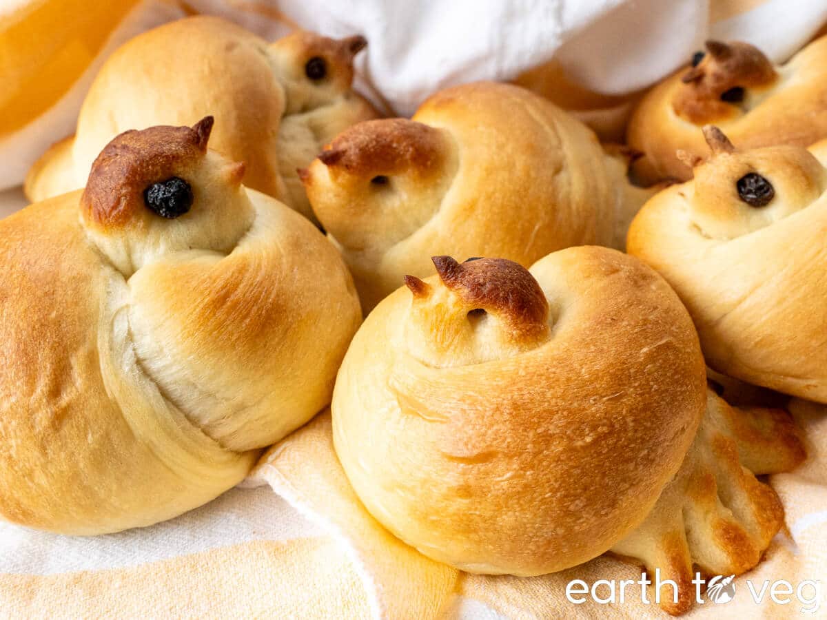A small pile of Russian Easter bird buns resting on a kitchen tablecloth.