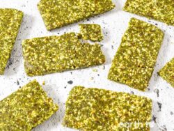 Homemade matcha lara bars on a white tabletop.